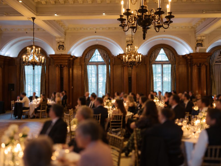 Guests networking at a formal chandelier-lit corporate dinner