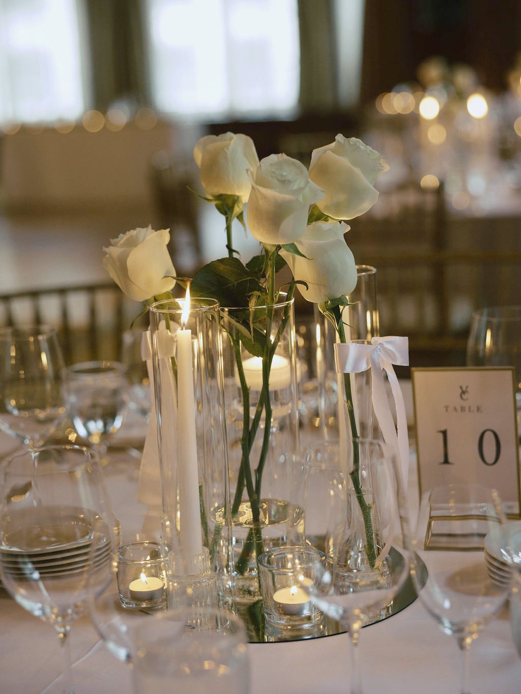 White roses, candlelight and table number ten at an elegant reception