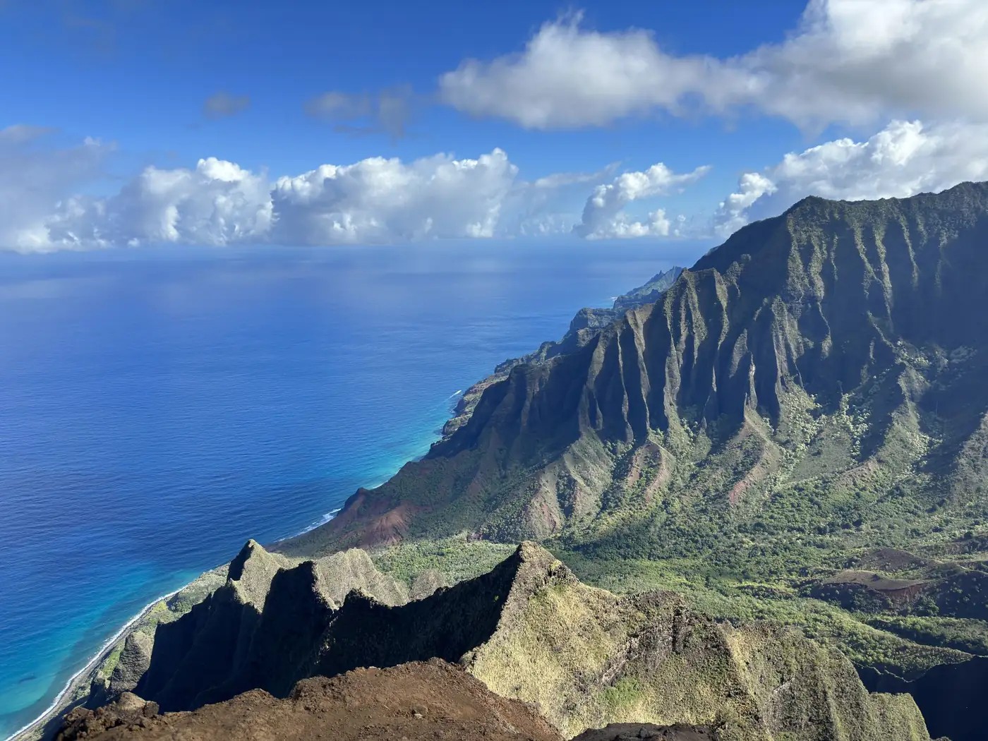 Dramatic green mountain ridges meeting the blue Pacific Ocean