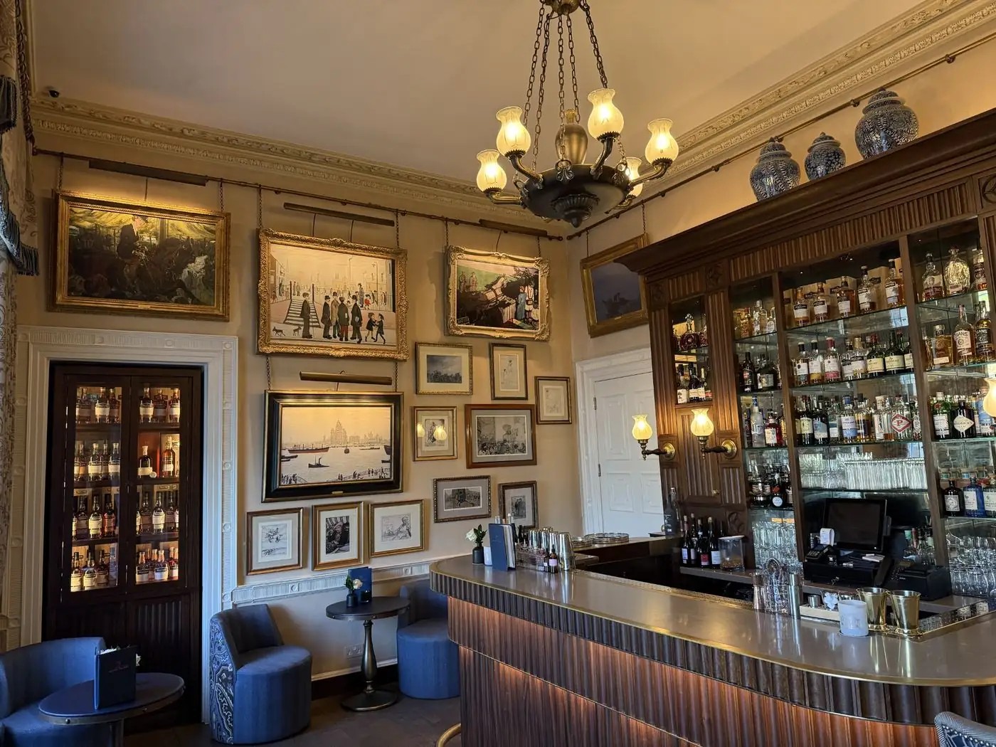 Warm wood-panelled hospitality bar with artwork and a curated bottle display