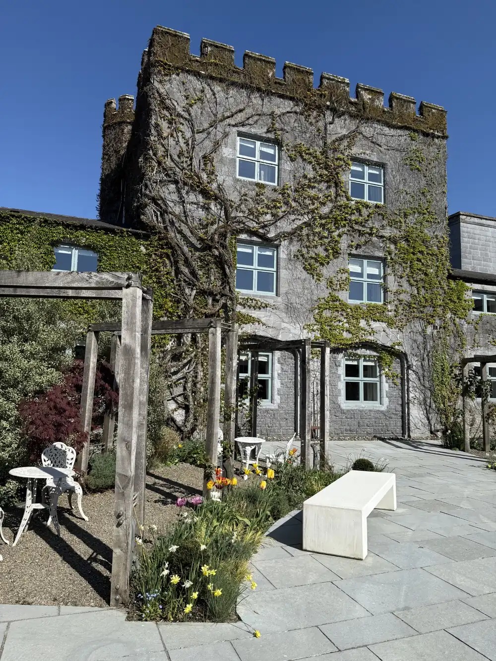 Ivy-covered heritage hospitality property with a garden terrace