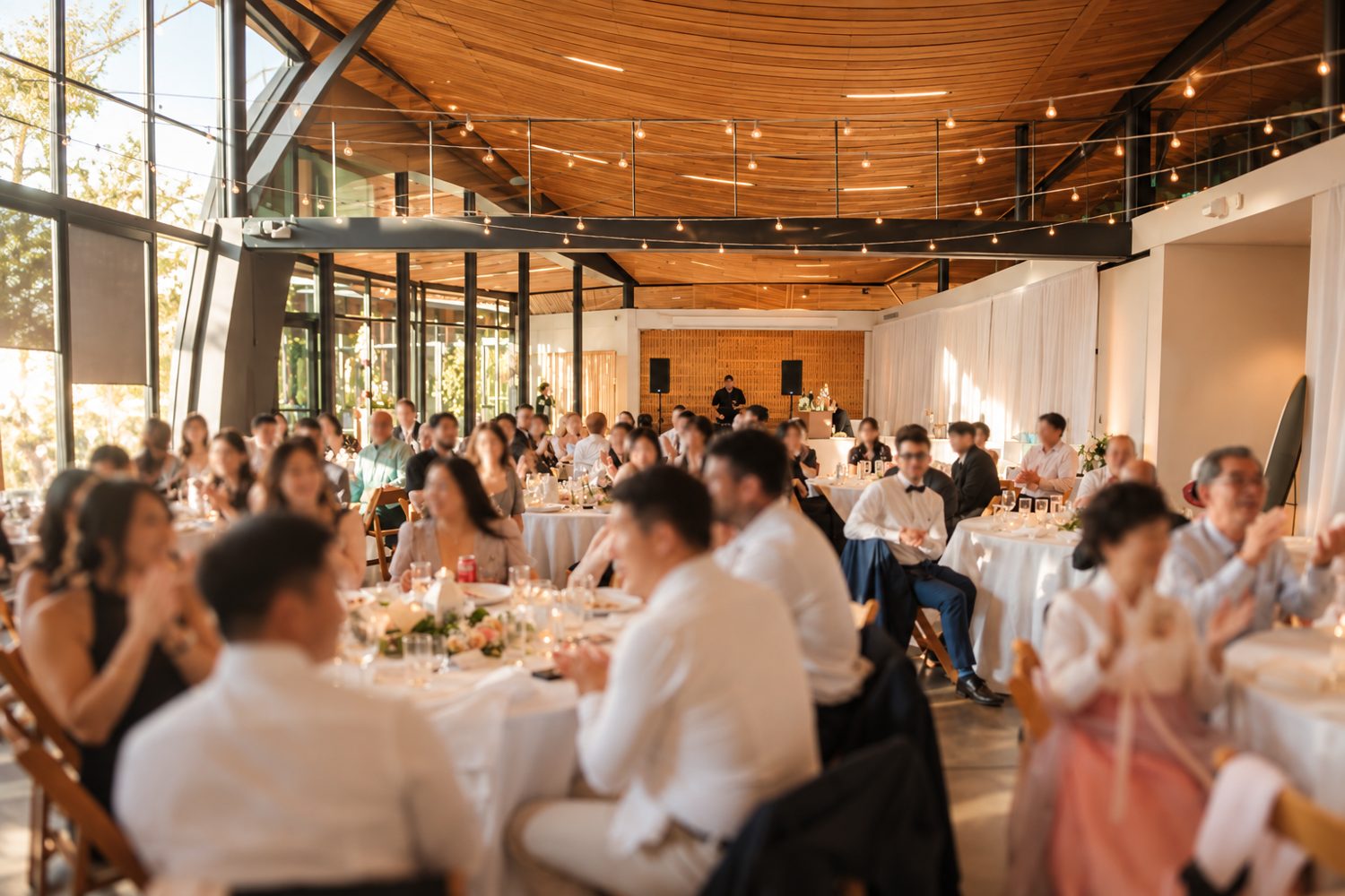 Guests celebrating at a warm, sunlit wedding reception